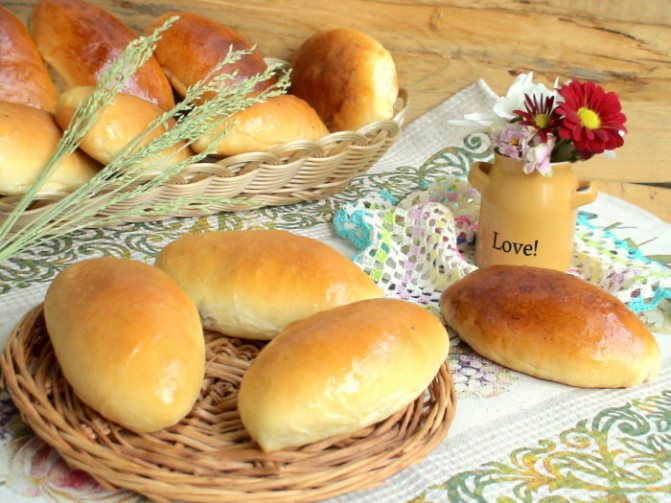 домашние пирожки с сыром и яйцом на столе и в корзине