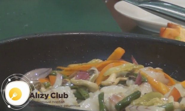 Поверх овощей выкладываем кусочки рыбы и перемешиваем.