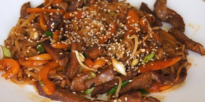 Рисовая лапша с кусочками свинины, кунжутом и овощами